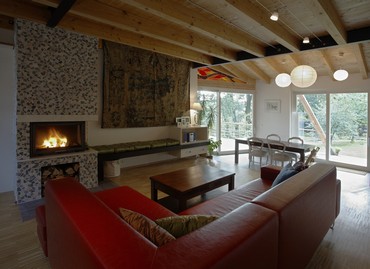 Interior of the living space, living room with fireplace and seating is two steps above the dining room, the dining room has direct exit to the terrace floor